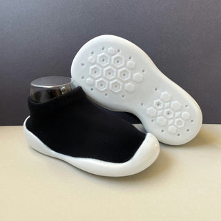 black sock shoes for toddlers with white rubber soles.